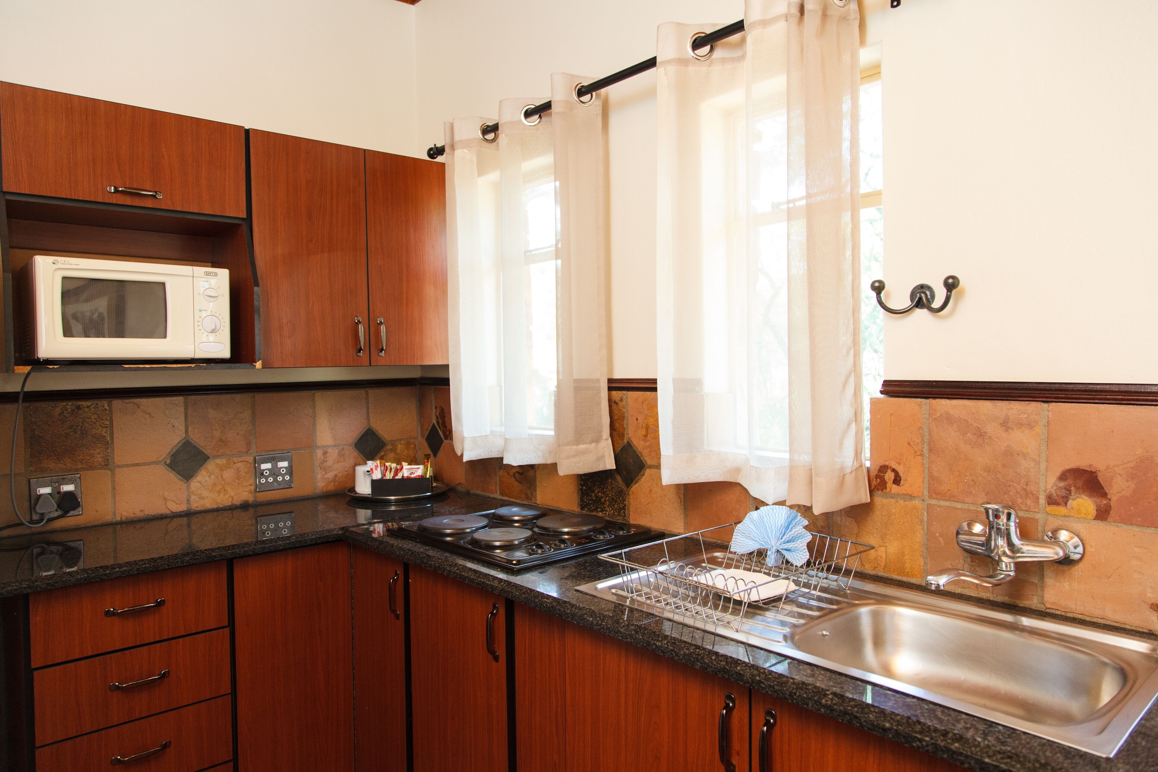 Una cocina con armarios de madera, un microondas, una estufa y un lavaplatos.