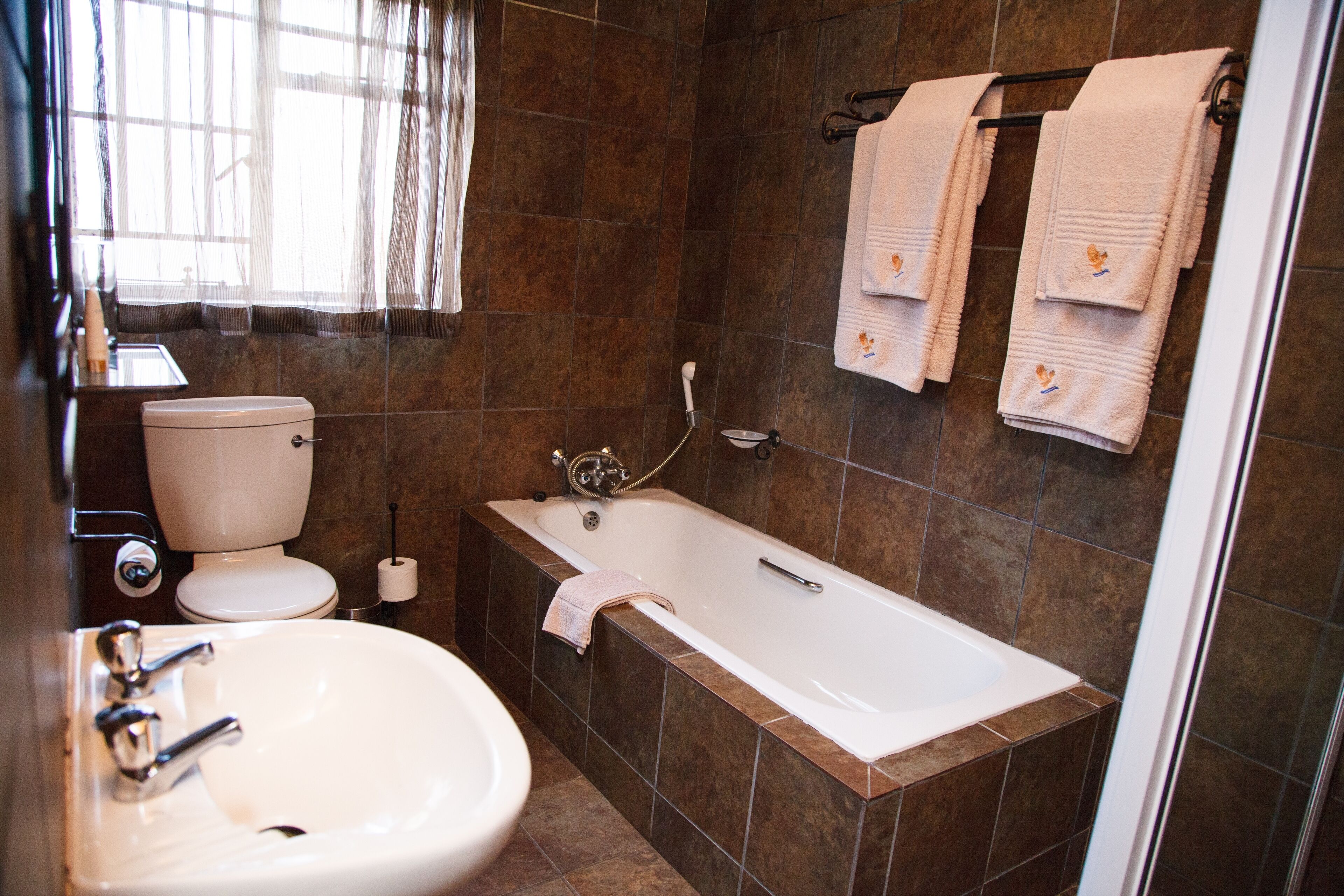A bathroom with a bathtub, toilet, and sink.