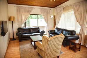 Alpehytte – deluxe, 2 soverom, resort-utsikt, hageområde (3) | Oppholdsområde | En 32-tommers Flatskjerm-TV med Parabol-TV samt TV