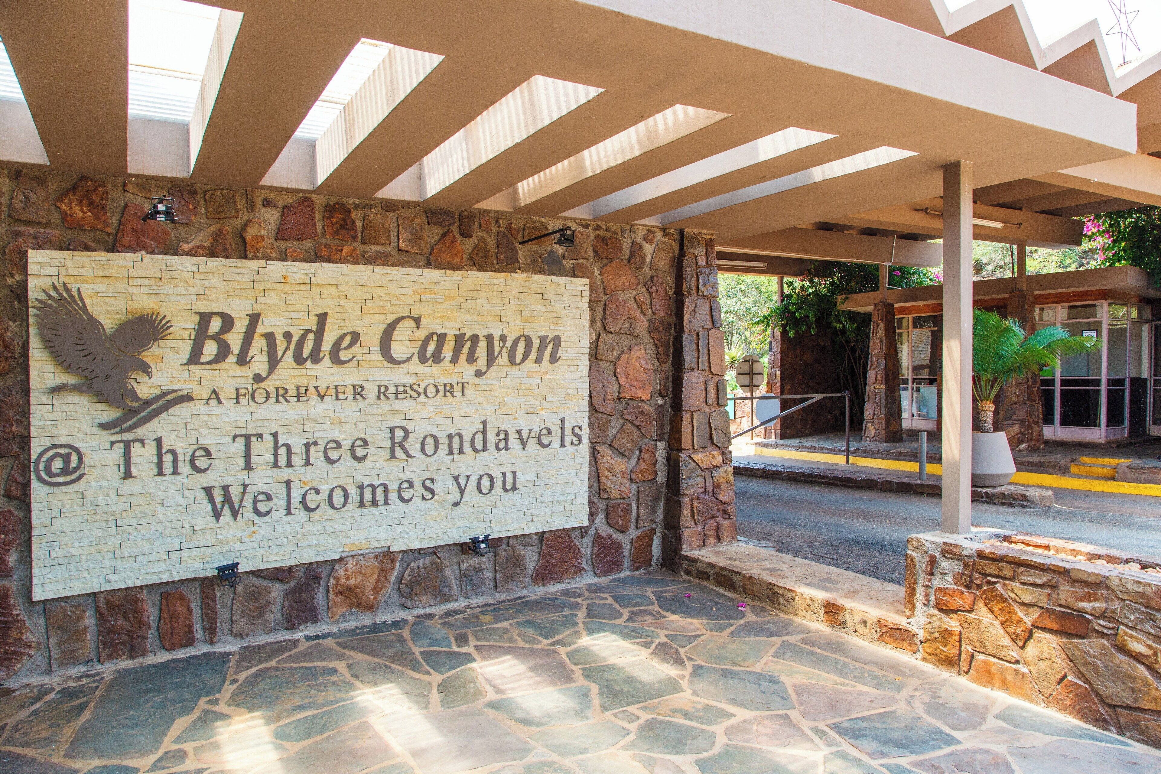 A stone wall with a sign for Blyde Canyon, a Forever Resort, welcoming visitors.