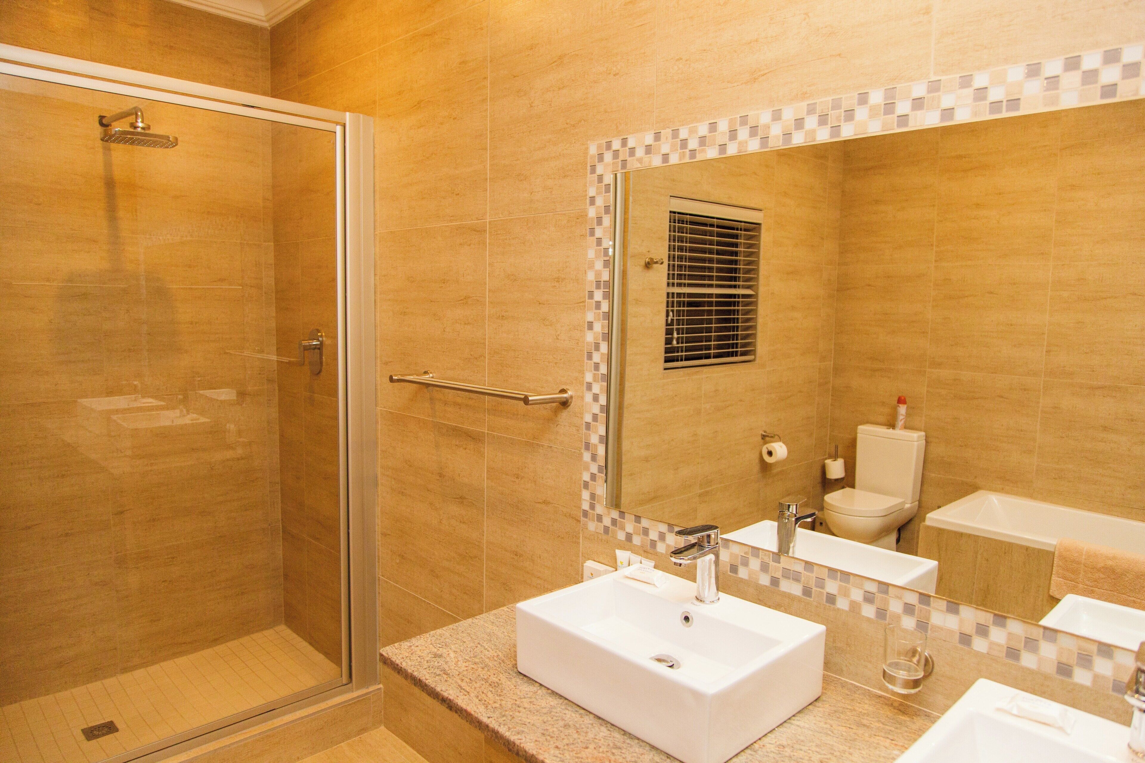 A bathroom with a shower, a sink, a toilet, and a bathtub.