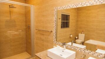 A bathroom with a shower, a sink, a toilet, and a bathtub.