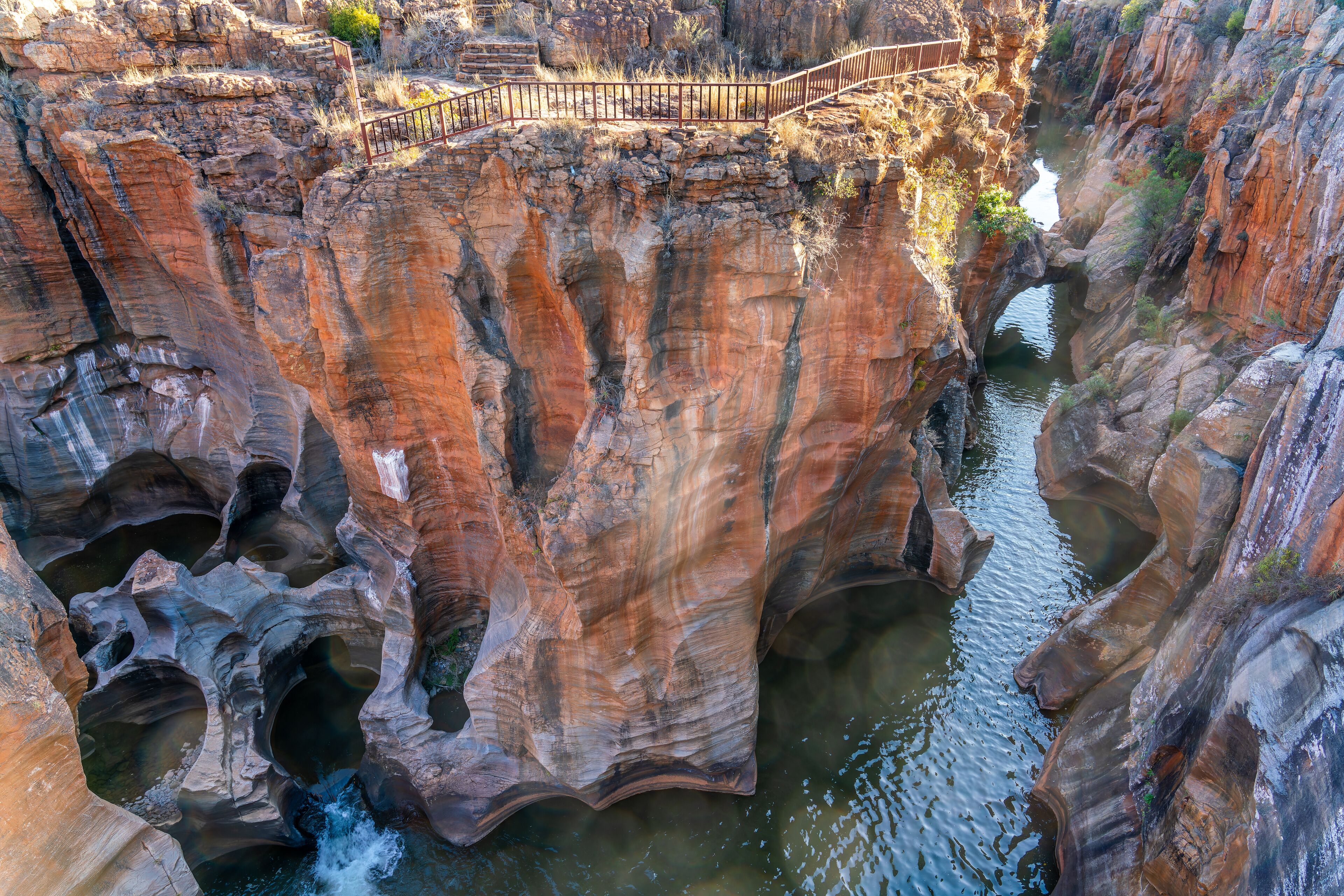 A canyon with a bridge and a waterfall.