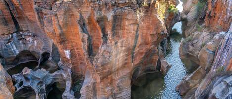 A canyon with a bridge and a waterfall.