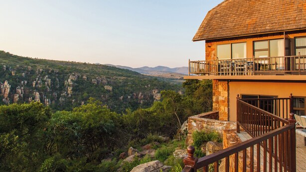 Un immeuble de deux étages doté d’un balcon donnant sur un paysage montagneux.
