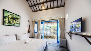 Un dormitorio con cama, televisión y puerta que da a un espacio exterior.