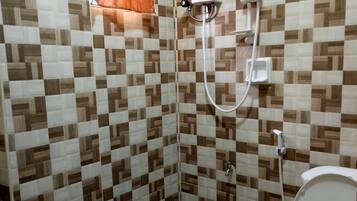 A bathroom with a checkered tile wall, a shower with a handheld showerhead, and a toilet.