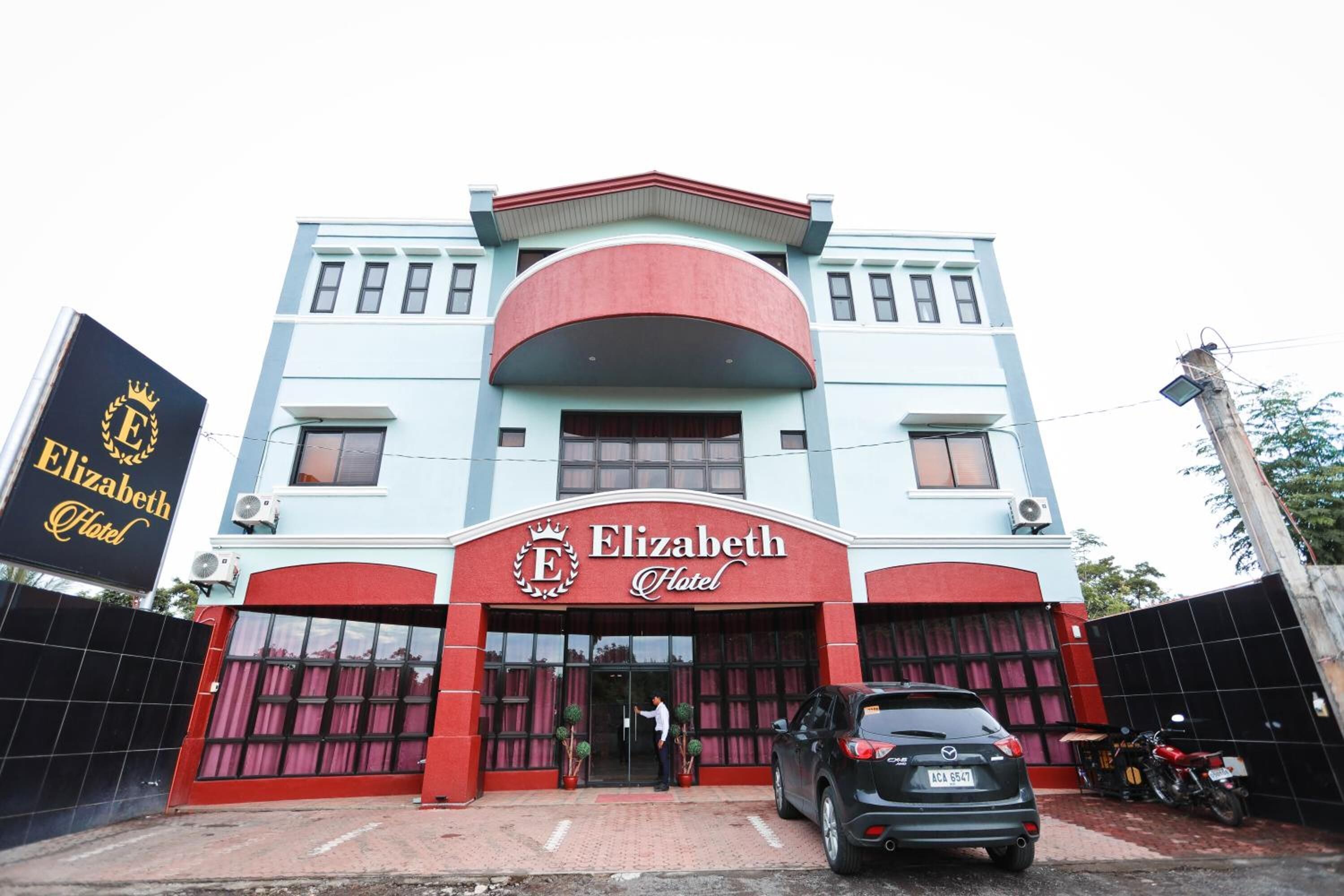 A building with a prominent 'Elizabeth Hotel' sign, featuring a classic architectural style with a red and blue facade.
