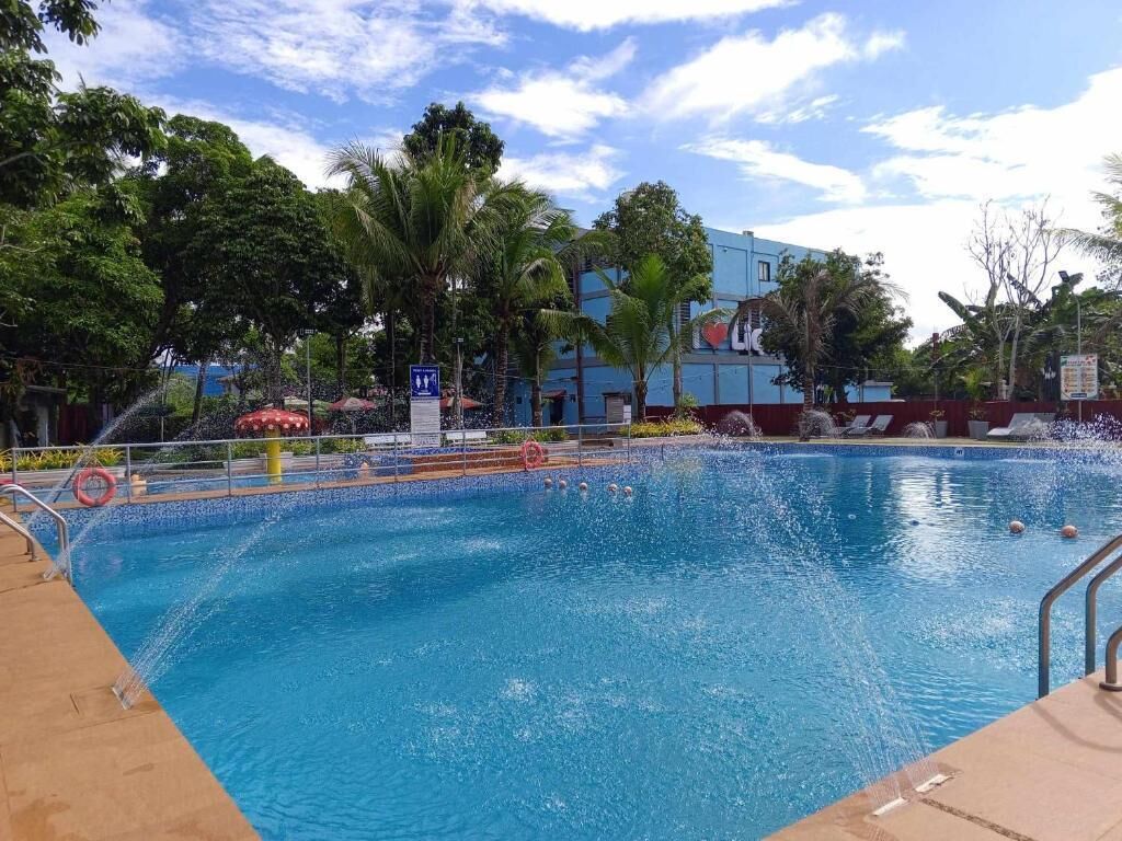 A swimming pool with a blue sky and palm trees in the background.