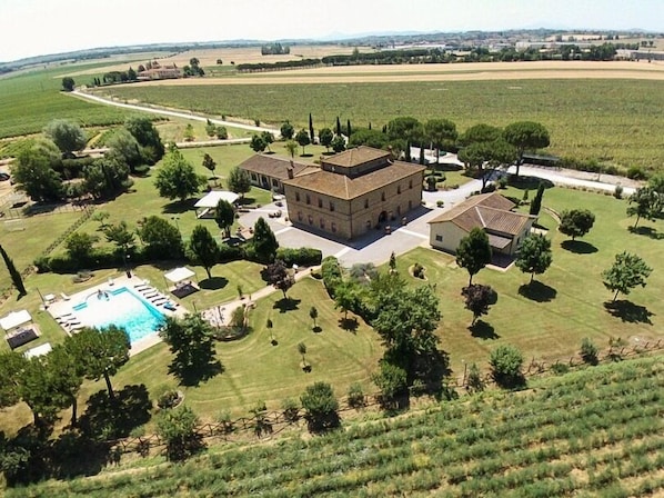 A large estate with a central building surrounded by manicured lawns, a swimming pool, and vineyard fields. - Agriturismo La Colmata (Monte San Savino)