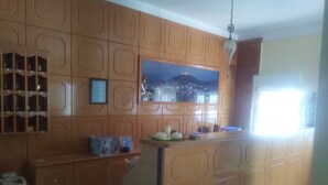 Una cocina con armarios de madera, un microondas integrado y un ventanal.
