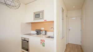 Une cuisine compacte équipée d’un four à micro-ondes, d’une machine à café et d’un évier.