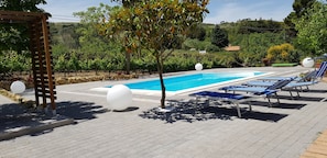 A swimming pool with lounge chairs and a pergola. - Bed House Floristella (Enna)