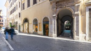A historic building with arched doorways and a cobblestone street. - Ara di Marte Suites (Rome)