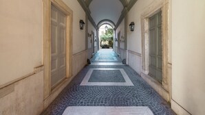 A corridor with a tiled floor, arched ceiling, and doors on either side. - Ara di Marte Suites (Rome)