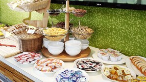 Un bufé con distintos alimentos, como pan, queso y bocadillos empaquetados.