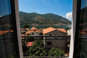 A view of a coastal town with buildings and a mountain in the background. - Hotel Alkima (Kotor)