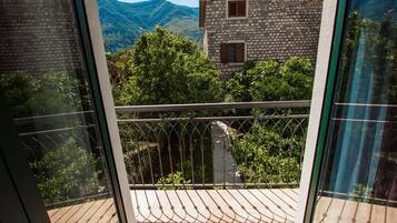 Un balcón con vista a un edificio de piedra y montañas.