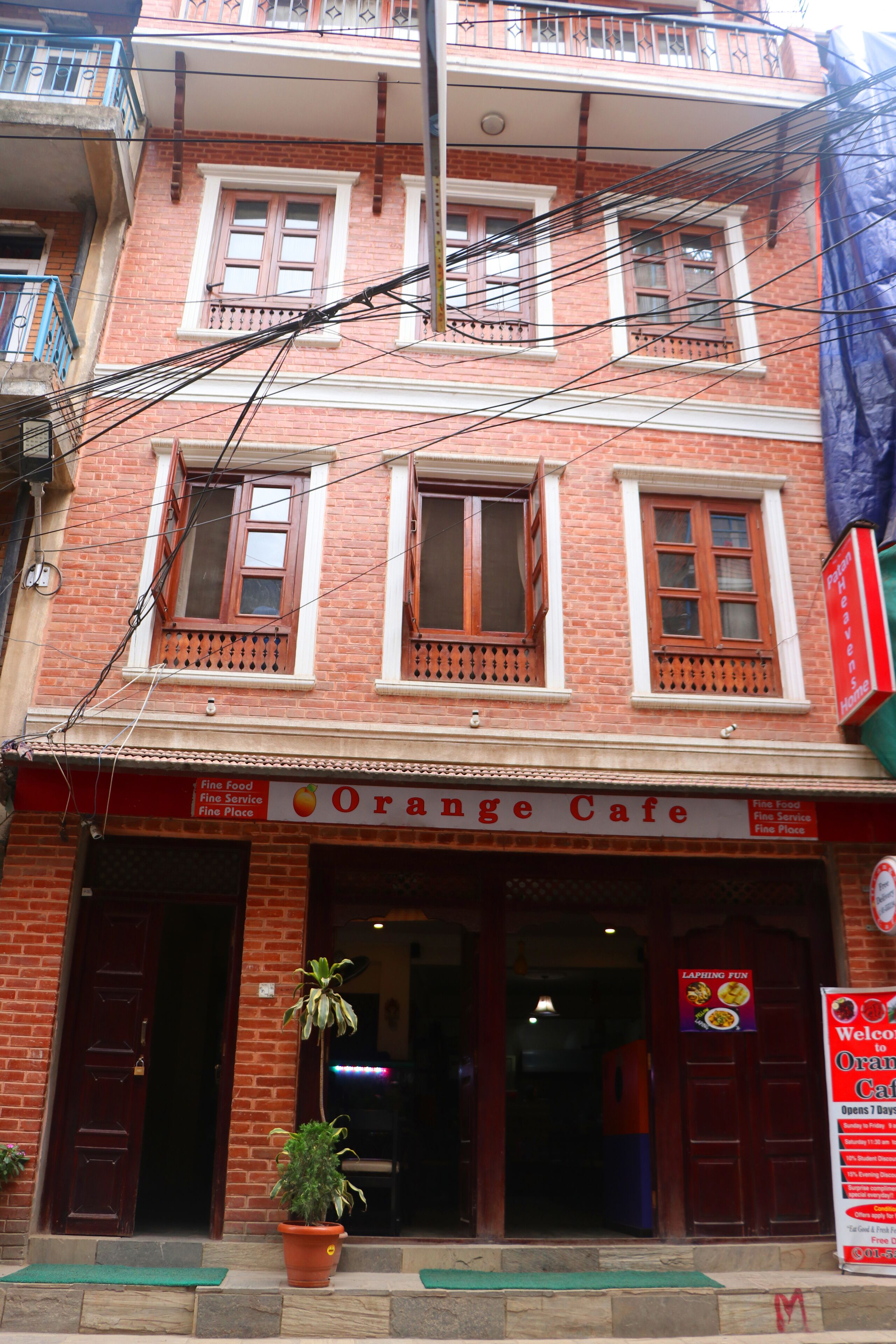 Ein zweistöckiges Backsteinhaus mit einem Schild für Orange Café.