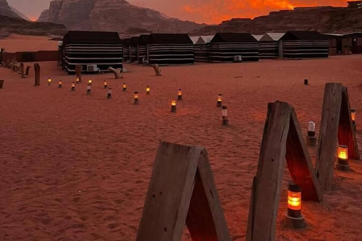 A desert landscape with wooden structures and lanterns.