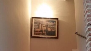 A marble staircase with circular handrails and a framed picture on the wall above. - Hotel San Miguel (Segovia)