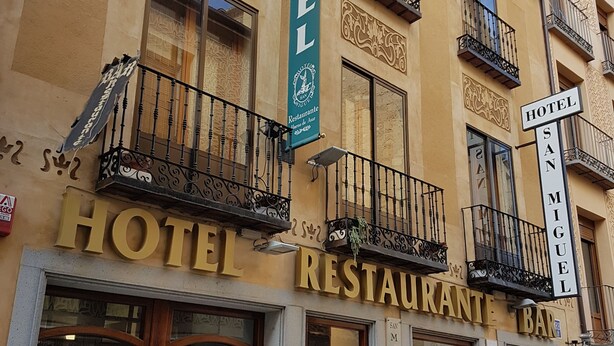 A hotel with a restaurant and bar on the ground floor, featuring ornate balconies and large windows. - Hotel San Miguel (Segovia)