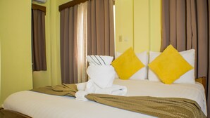 Una habitación de hotel con una cama, una toalla y dos almohadas.