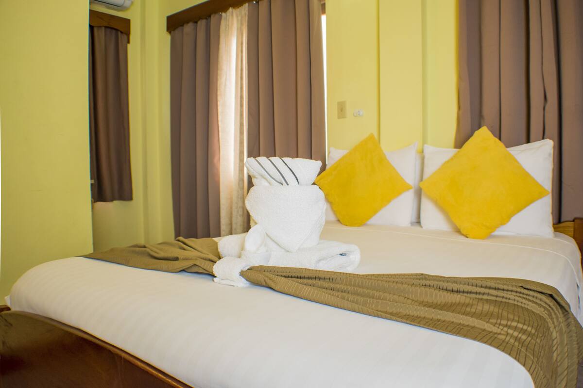 Una habitación de hotel con una cama, una toalla y dos almohadas.