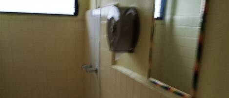 Un baño con inodoro, lavamanos y espejo.