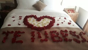 A bed with a heart-shaped arrangement of rose petals and the words "I love you" spelled out in rose petals. - Astoria (Chisinau)