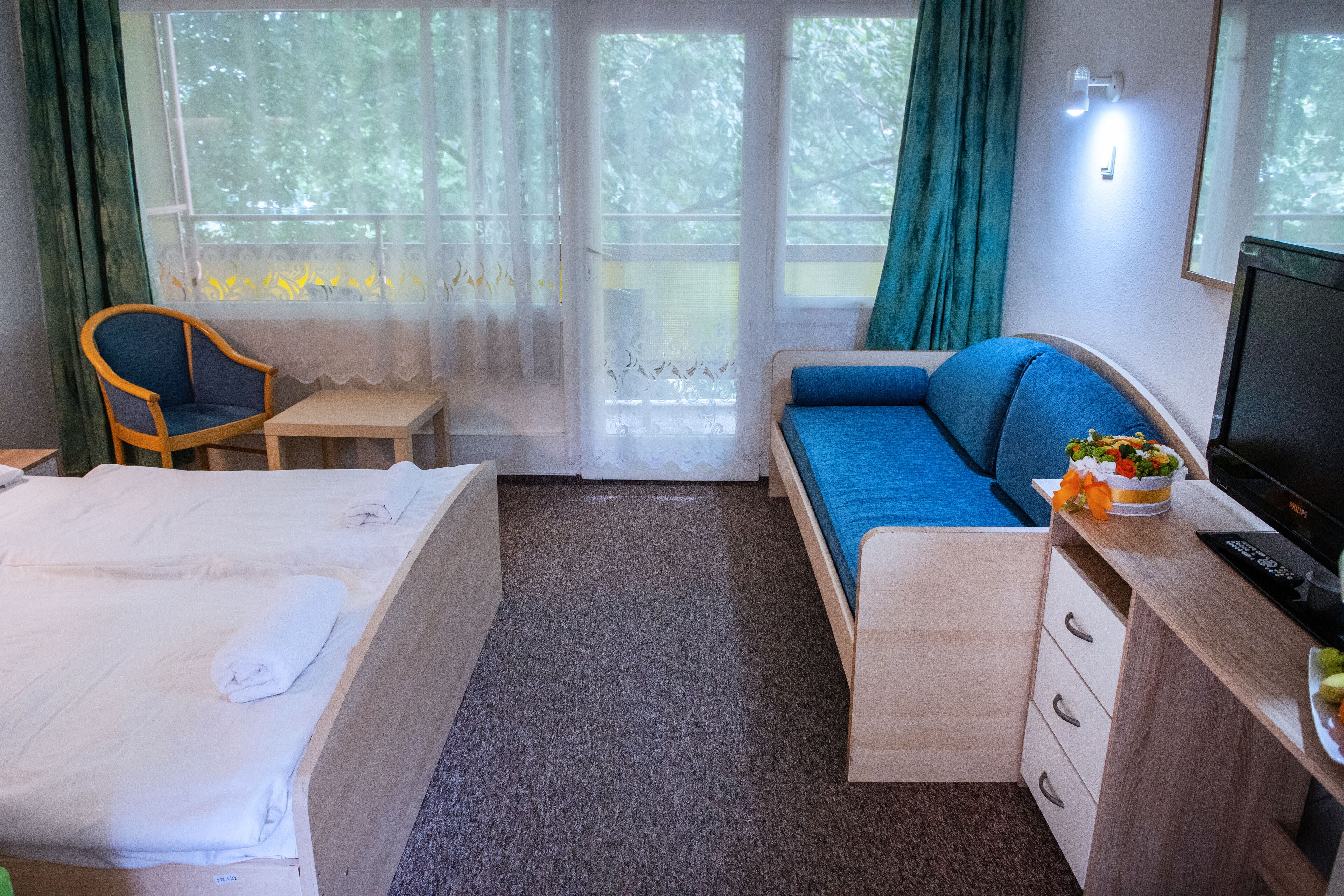 Una habitación de hotel con cama, sofá, escritorio y una silla.
