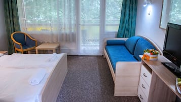 Una habitación de hotel con cama, sofá, escritorio y una silla.
