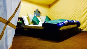 A tent-style room with a bed, pillows, and a small window. - D Camp (Leh)