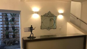 A staircase with a glass railing, a wall-mounted light fixture, and a decorative metal piece. - Hostel Pajuçara (Maceió)