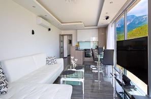 Deluxe-Apartment, 1 Schlafzimmer, Terrasse, Meerblick | Wohnbereich | Smart-TV, DVD-Player, Kinderspielzeug, Fußbodenheizung