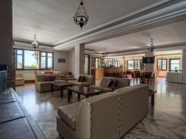 Amplia sala de estar con sofás de cuero, una mesa de centro y un comedor con taburetes de bar.