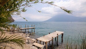 A wooden dock extending into calm waters with a mountainous backdrop. - Baraka Atitlan - Lake & Beach (San Marcos La Laguna)