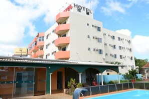 Um hotel com piscina, várias varandas e um aviso indicando um restaurante.