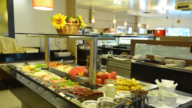 Un buffet proposant une variété de plats et un panier de tournesols disposé sur un comptoir en verre.