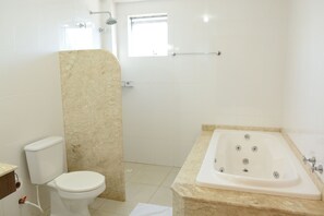 Un baño con inodoro, bañera y ducha.