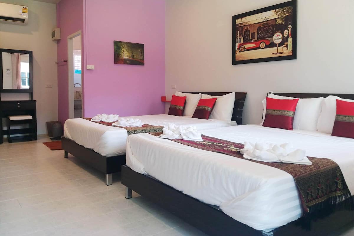 A hotel room with two beds, a pink wall, a painting, and a minibar.