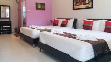 Habitación de hotel con dos camas, una pared rosa, un cuadro y un minibar.