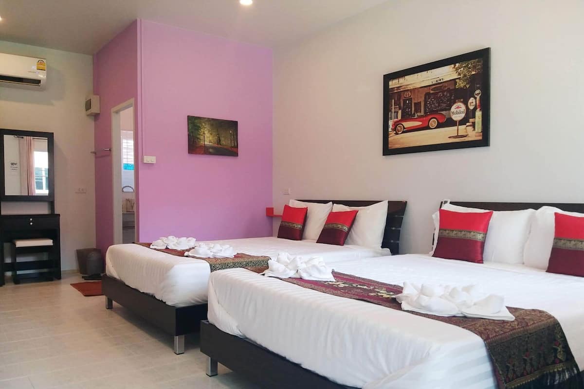 A hotel room with two beds, a painting, and a door leading to a bathroom.