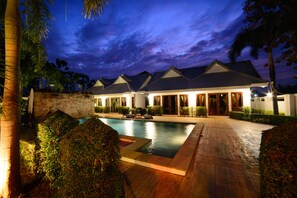 Un resort con piscina, varias habitaciones y un jardín bien cuidado.