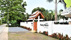A white building with a sign reading "Rung Nara Pool Villa." - RungNara Pool Villa (San Sai)