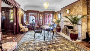 A grand room with a chandelier, a fireplace, and ornate furniture. - InnBuffalo off Elmwood (Buffalo)