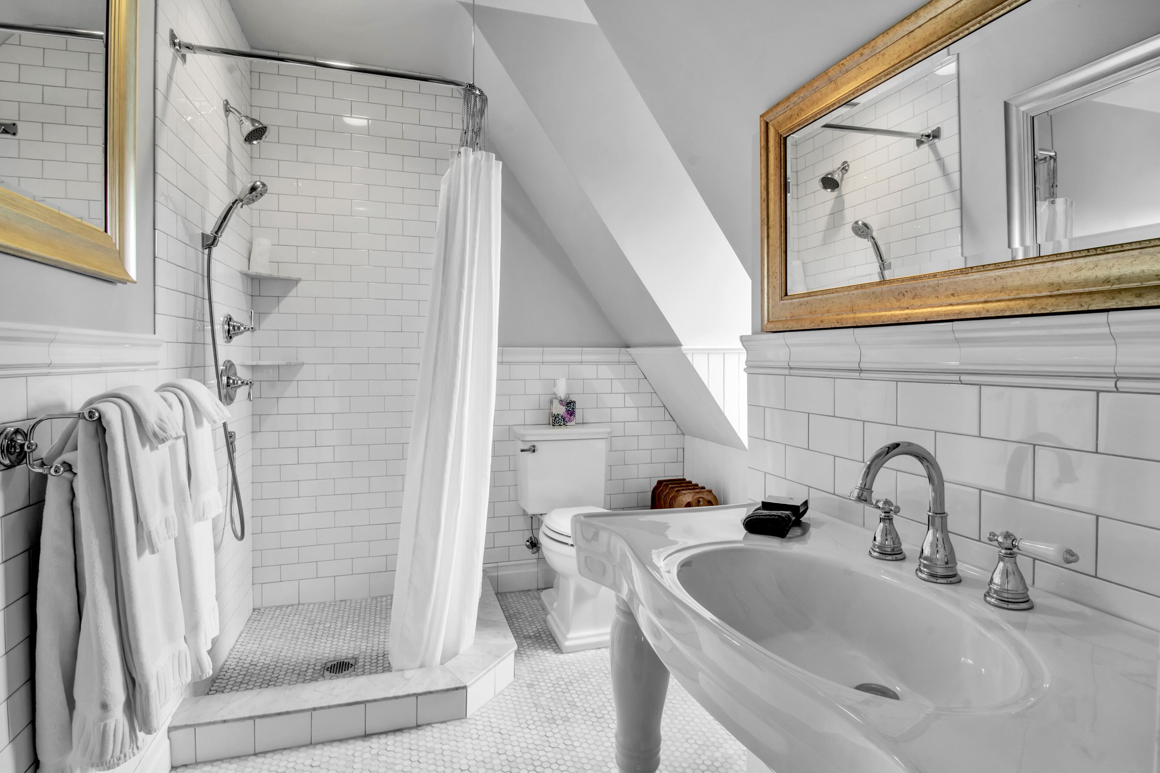 A modern bathroom with a walk-in shower, a large sink, and a toilet.
