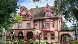 A large, two-story building with a prominent entrance, multiple windows, and a well-maintained garden. - InnBuffalo off Elmwood (Buffalo)