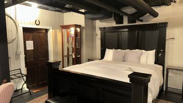 Une chambre à coucher avec un grand lit, une armoire en bois, un miroir et un radiateur.