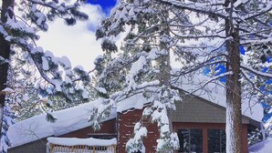 A snow-covered building with a red brick facade, a wooden porch, and a door marked "OFFICE". - 113 Standard Condo (Mammoth Lakes)